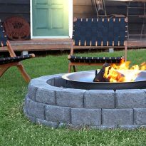 Lawn chairs and a fire pit that is encircled by charcoal coloured Hudson blocks | Featured image for Hudson Stone.