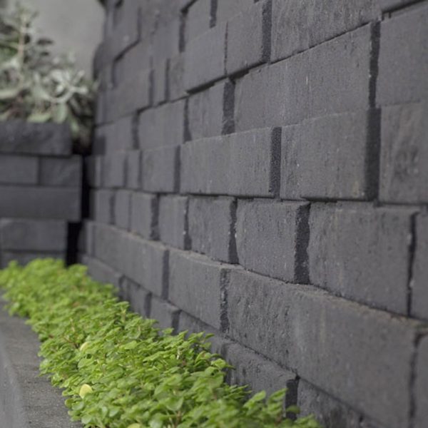 Zoomed in view of the base of a wall made from Natural Impressions Duostone blocks | Featured image for Natural Impressions Duostone.