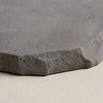 CentenaryLandscapePaversAug202_029 Gray concrete paver with a rough, textured edge and small air pockets.