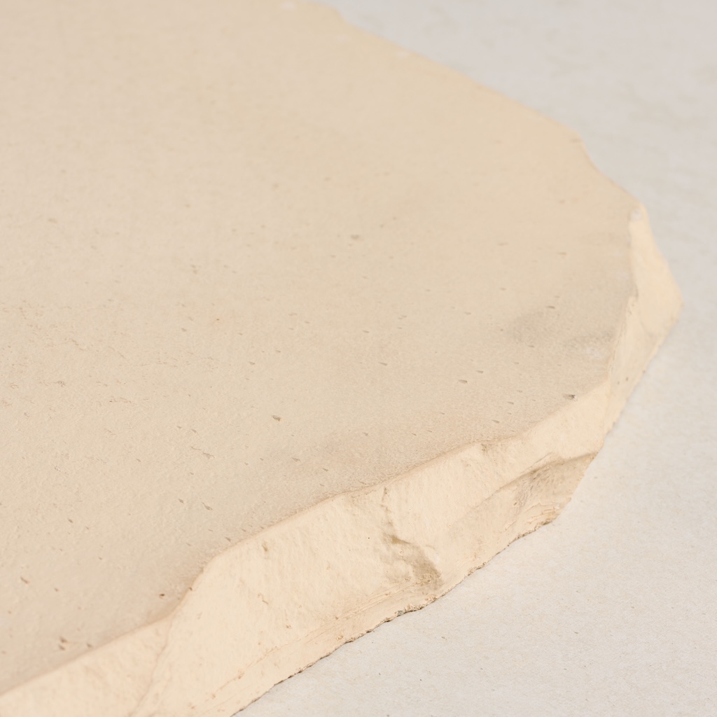 CentenaryLandscapePaversAug202_035 Light beige concrete paver with a textured, irregular edge and a smooth surface.