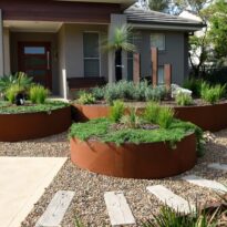 Photo of a round garden bed with plants in them created with FormBoss REDCOR Steel Edging.